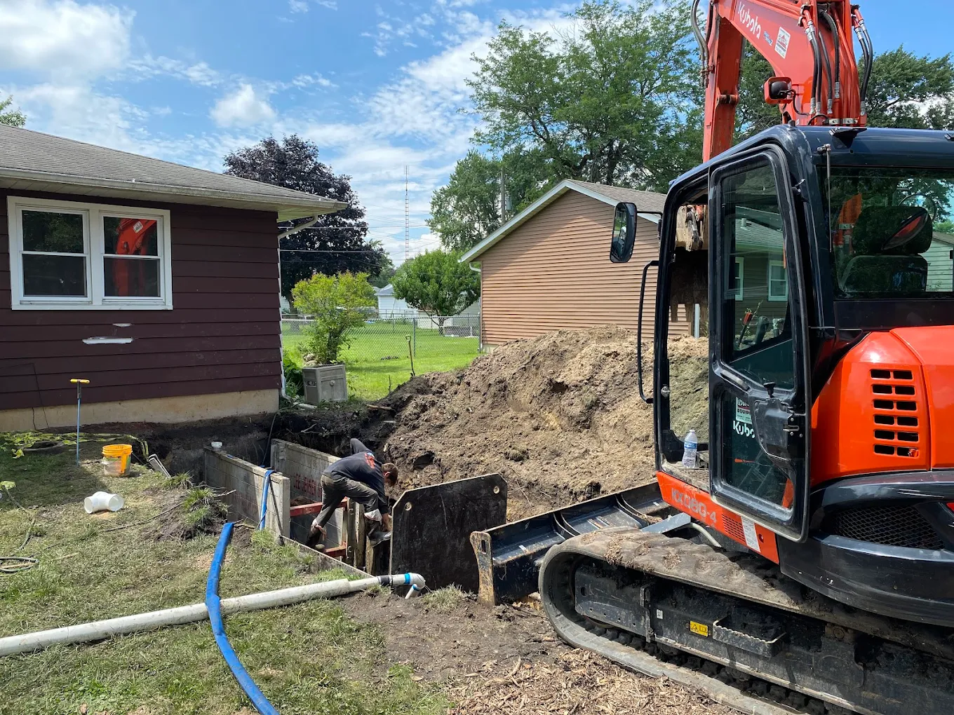 Residential water line trench next to a home foundation